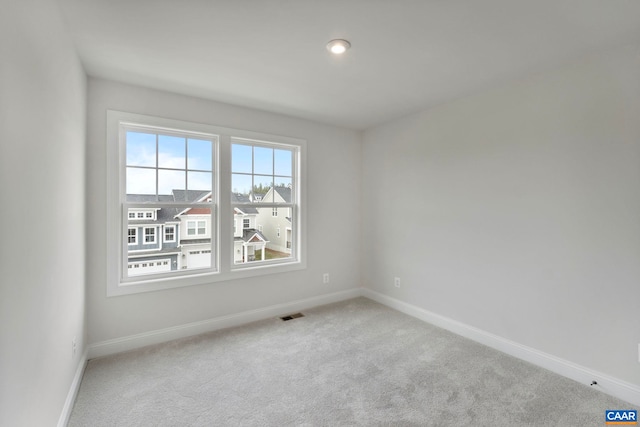 carpeted empty room with baseboards and visible vents