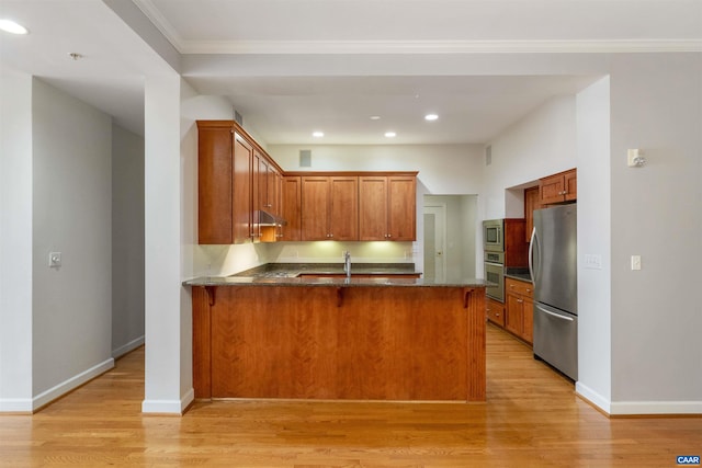112 5th St SE Unit 3D, Charlottesville, VA 22902 - kitchen featuring stainless steel appliances, a peninsula, light wood finished floors, dark stone counters, and recessed lighting