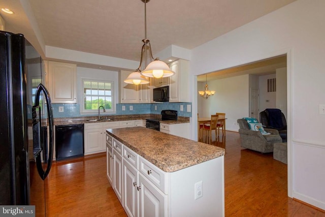 7204 Morris Rd, Spotsylvania, VA 22551 - kitchen featuring black appliances, a sink, light wood finished floors, and backsplash
