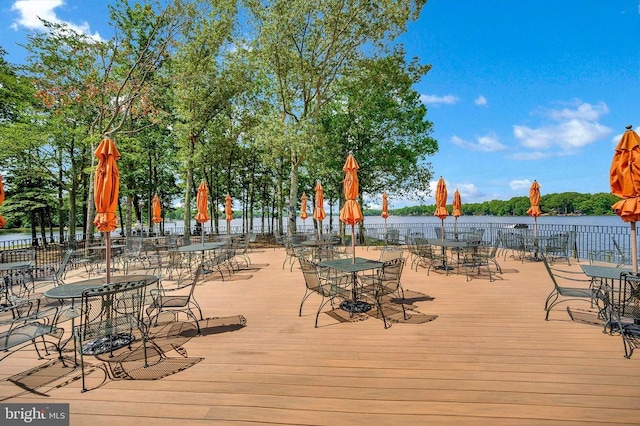wooden terrace featuring a water view and outdoor dining space