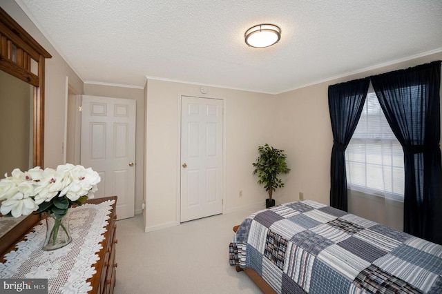 bedroom with a textured ceiling, ornamental molding, and light colored carpet
