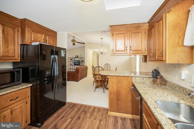 kitchen featuring appliances with stainless steel finishes, a ceiling fan, brown cabinets, dark wood finished floors, and a sink