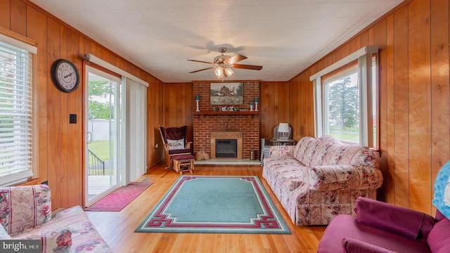 909 Mill Creek Rd, Luray, VA 22835 - living room with a fireplace, ceiling fan, wooden walls, and wood finished floors