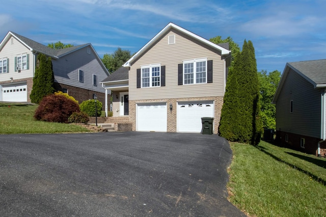 traditional home featuring brick siding, asphalt driveway, a front yard, and an attached garage