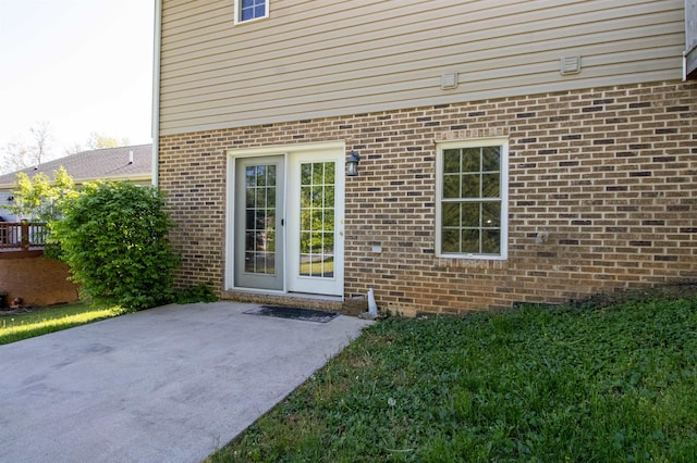 entrance to property featuring a patio area and brick siding