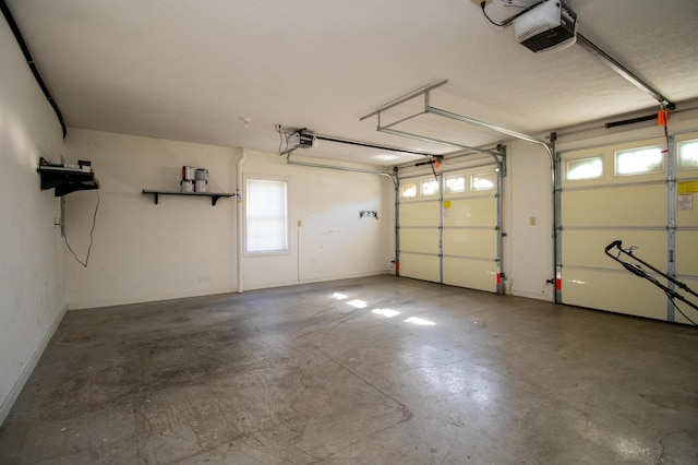 garage featuring a garage door opener and baseboards