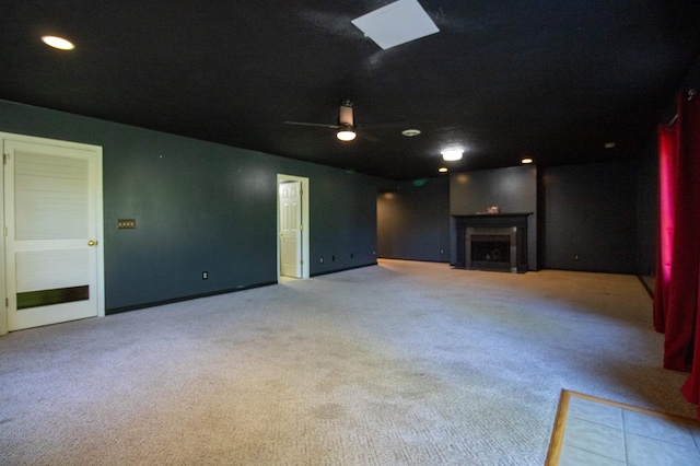 unfurnished living room featuring carpet floors, a fireplace, a ceiling fan, baseboards, and recessed lighting