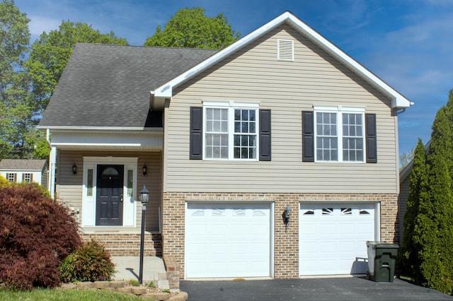 view of front of property featuring an attached garage, brick siding, driveway, and a shingled roof