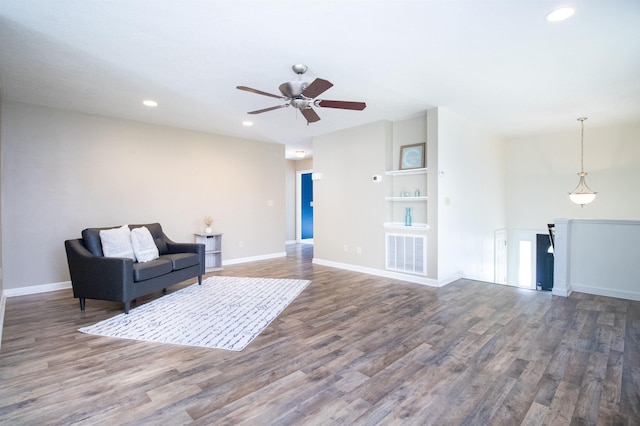 living area featuring wood finished floors, recessed lighting, ceiling fan, baseboards, and built in shelves