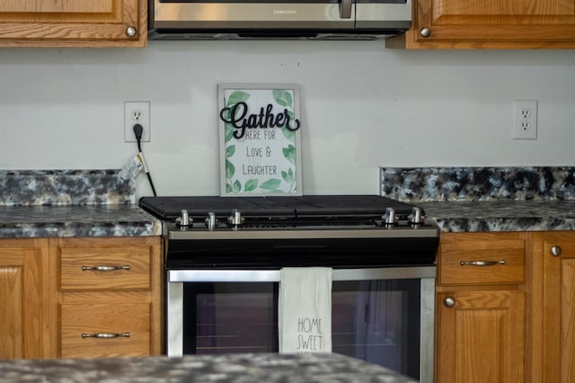 kitchen with stainless steel appliances, dark countertops, and brown cabinetry