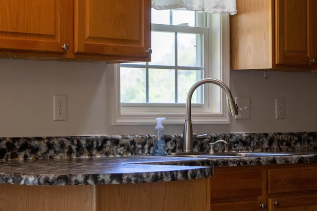 detailed view of a sink and brown cabinets