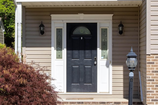 entrance to property featuring brick siding