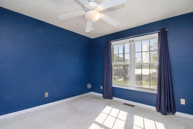 empty room featuring carpet flooring, baseboards, and ceiling fan