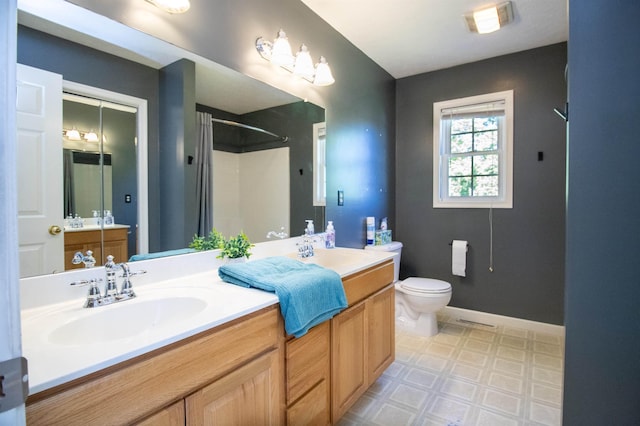 full bathroom with tile patterned floors, a shower, toilet, double vanity, and baseboards