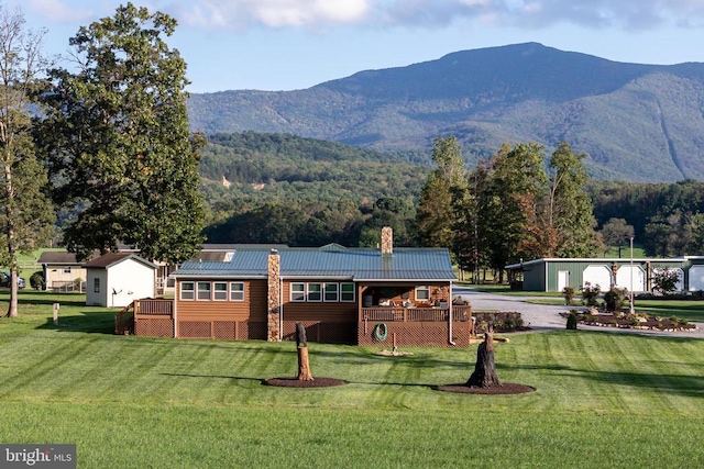 528 Ellis Dr, Luray, VA 22835 - rear view of property featuring a chimney, a yard, metal roof, a standing seam roof, and a deck with mountain view