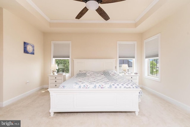 bedroom with ceiling fan, light colored carpet, ornamental molding, and a raised ceiling