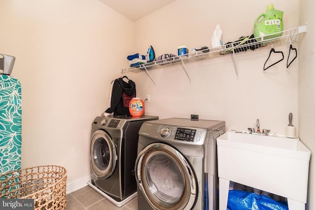 washroom with sink, washer and clothes dryer, and tile patterned floors