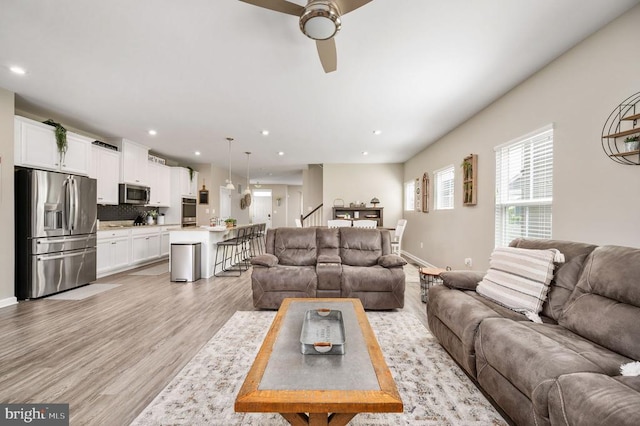 living room with stairway, light wood-style flooring, ceiling fan, recessed lighting, and baseboards