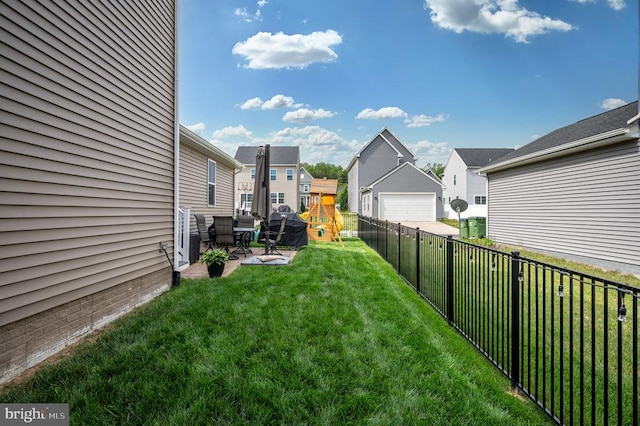 view of yard featuring a playground, a residential view, a detached garage, and a patio area