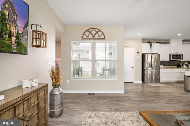interior space featuring wood finished floors, baseboards, and recessed lighting