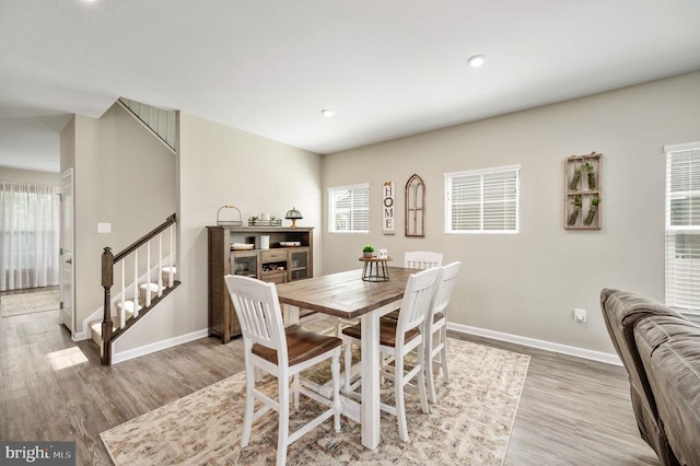 dining room featuring stairway, light wood-type flooring, baseboards, and recessed lighting