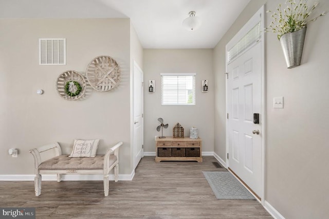 foyer entrance with wood finished floors and baseboards