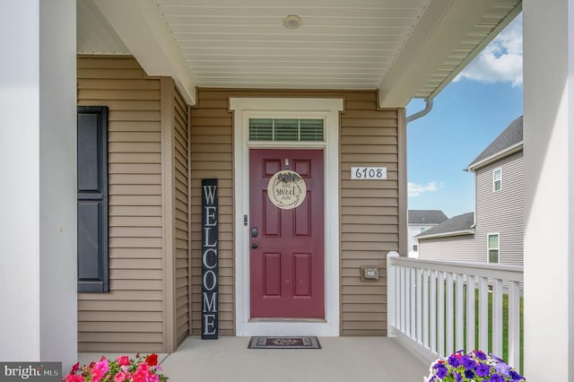 view of exterior entry featuring covered porch