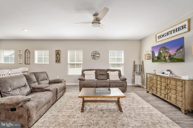 living room featuring a ceiling fan, healthy amount of natural light, and wood finished floors