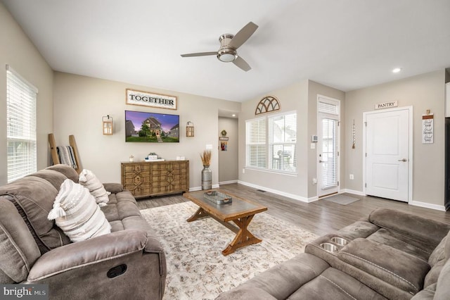 living area with ceiling fan, plenty of natural light, wood finished floors, baseboards, and recessed lighting