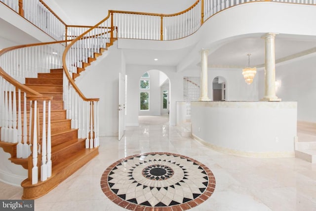 3714 Fairways Ct, Fredericksburg, VA 22408 - foyer entrance featuring arched walkways, decorative columns, inlaid floor details, a towering ceiling, and stairway
