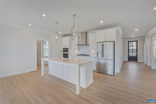 36 Mary Jackson Ct, Charlottesville, VA 22902 - kitchen featuring appliances with stainless steel finishes, crown molding, wall chimney exhaust hood, a kitchen island with sink, and light countertops