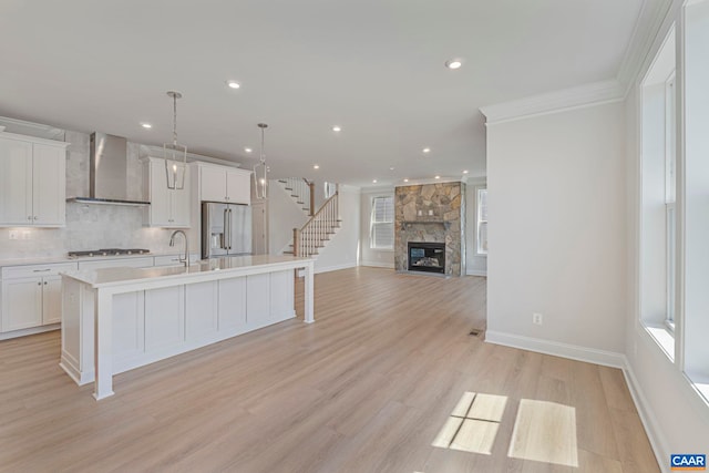 36 Mary Jackson Ct, Charlottesville, VA 22902 - kitchen with appliances with stainless steel finishes, wall chimney range hood, a kitchen island with sink, light countertops, and white cabinetry