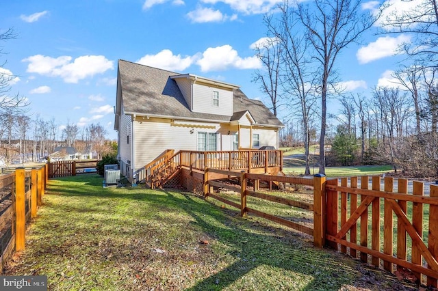 back of house featuring a wooden deck, central AC unit, and roof with shingles