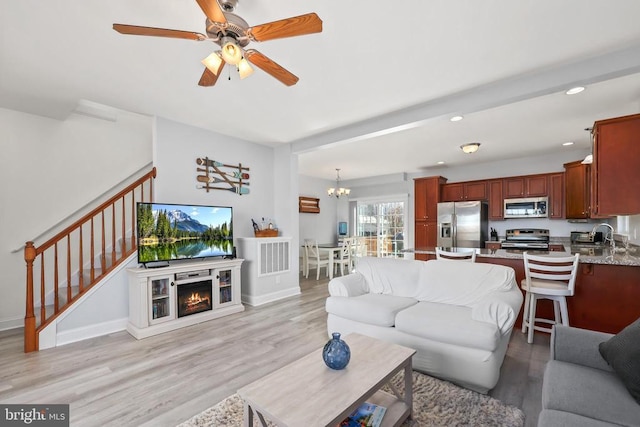 living area with recessed lighting, light wood-style floors, a chandelier, stairs, and ceiling fan