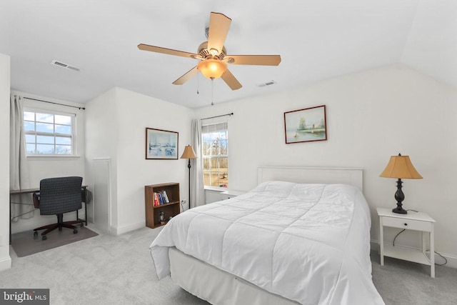 bedroom with light colored carpet, multiple windows, baseboards, and a ceiling fan