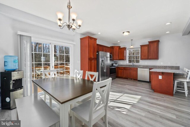dining area featuring a chandelier, light wood finished floors, and recessed lighting