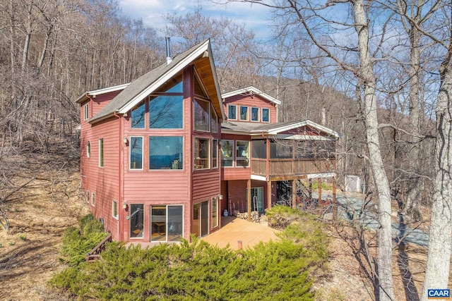 back of house with a sunroom and a wooden deck