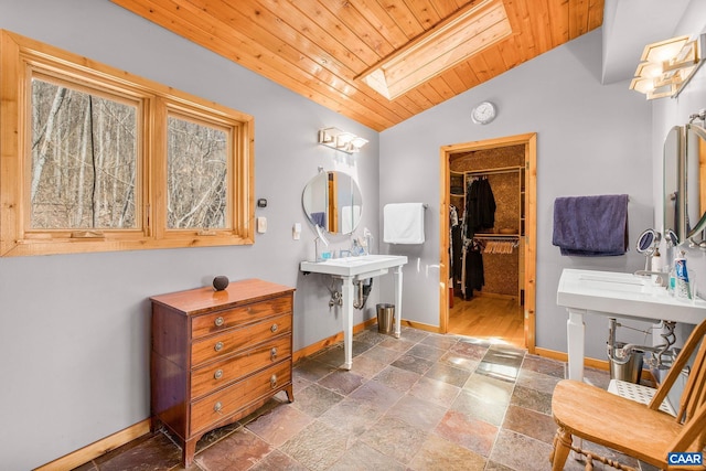 6696 Highlander Way, Crozet, VA 22932 - bathroom featuring a skylight, wooden ceiling, lofted ceiling, baseboards, and stone tile flooring