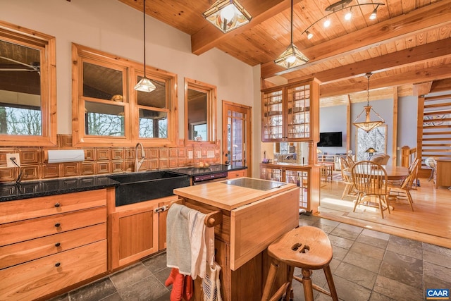 kitchen with wood counters, beam ceiling, wooden ceiling, and a sink