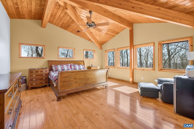 bedroom featuring light wood-style floors, baseboards, and vaulted ceiling with beams
