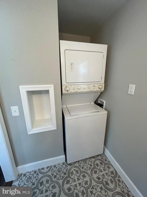 1346 Lakeshore Dr N, Louisa, VA 23093 - laundry area with stacked washer and clothes dryer and light tile patterned floors