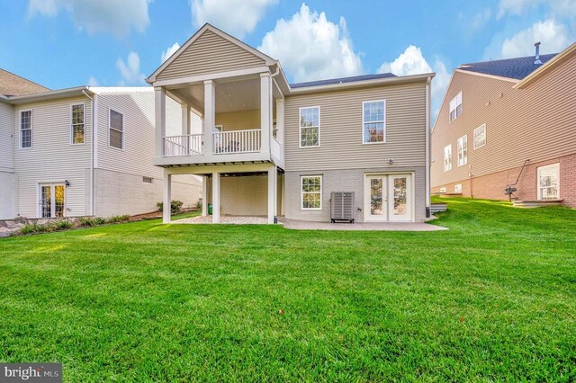 back of property with a lawn, central AC, and a patio