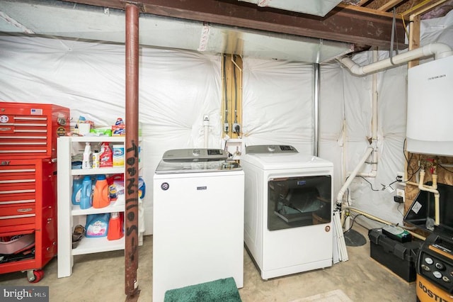 clothes washing area with washer and dryer and water heater