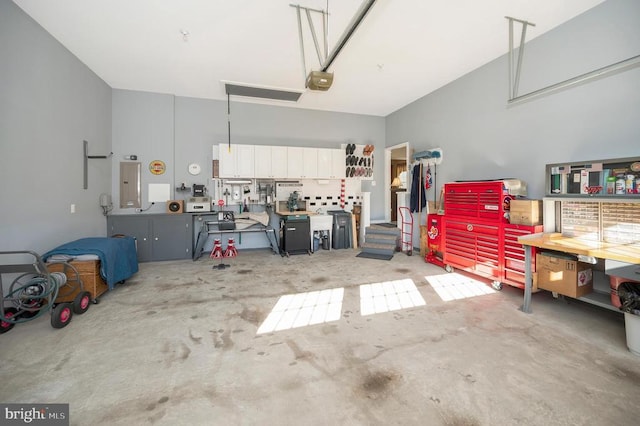 garage with a workshop area, electric panel, and a garage door opener