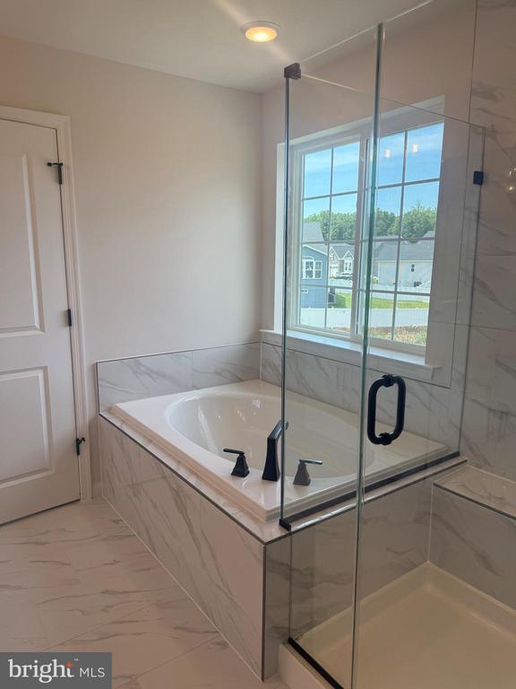 8720 Afton Dr, Spotsylvania, VA 22551 - full bathroom with marble look tile flooring, a garden tub, and a marble finish shower