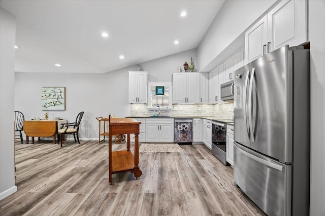 7 Oak View Dr, Staunton, VA 24401 - kitchen featuring appliances with stainless steel finishes, white cabinetry, tasteful backsplash, vaulted ceiling, and light wood finished floors
