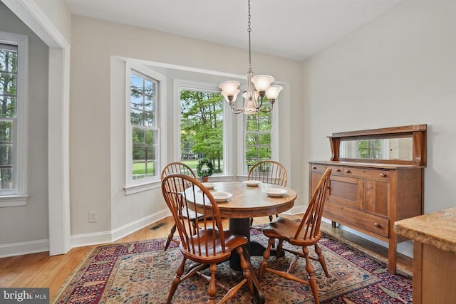 11208 Valor Bridge Dr, Spotsylvania, VA 22551 - dining room featuring light wood-style flooring, baseboards, a healthy amount of sunlight, and a notable chandelier