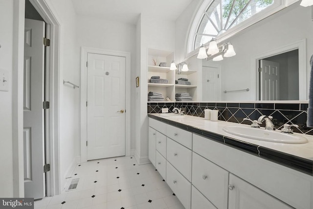 11208 Valor Bridge Dr, Spotsylvania, VA 22551 - bathroom with double vanity, decorative backsplash, baseboards, and a sink