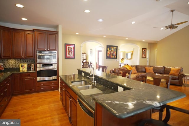32314 Deep Meadow Ln, Locust Grove, VA 22508 - kitchen featuring stainless steel appliances, arched walkways, a sink, a kitchen breakfast bar, and an island with sink