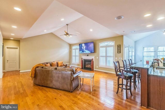 32314 Deep Meadow Ln, Locust Grove, VA 22508 - living room featuring a ceiling fan, vaulted ceiling, light wood-type flooring, a fireplace with flush hearth, and baseboards